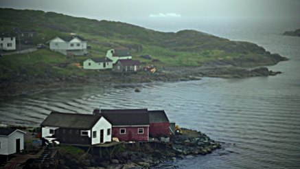 St. Anthony, Newfoundland, is located in the far northwestern corner of Newfoundland. It's a remote fishing hub and service center for western Newfoundland and southern Labrador. An iceberg, seen at the top of the photo, floats outside the entrance to the harbor.